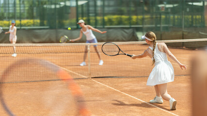 Portrait of concentrated sporty girl with tennis racquet and ball in her hands standing and ready...