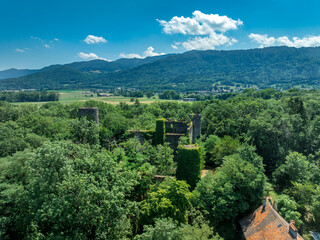 Aerial view of hilltop ruined castle Rochette in Savoy France with round keep, curtain walls rising above the commercial road below