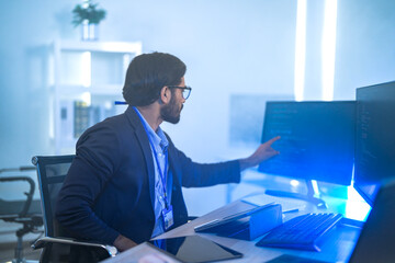 Diverse team of AI developers collaborating in a modern office. Indian male leading a discussion...