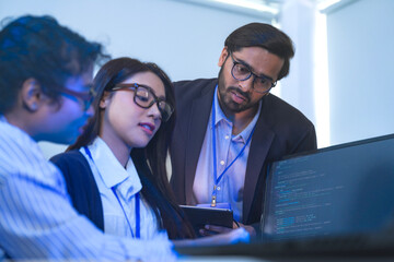 Diverse team of AI developers collaborating in a modern office. Indian male leading a discussion...