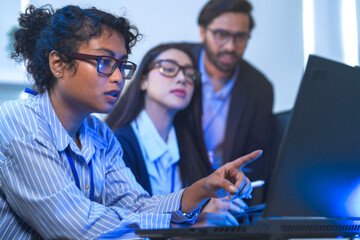 Diverse team of AI developers collaborating in a modern office. Indian male leading a discussion...