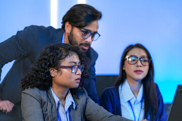 Diverse team of AI developers collaborating in a modern office. Indian male leading a discussion...