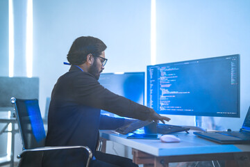 Diverse team of AI developers collaborating in a modern office. Indian male leading a discussion...