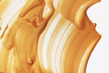 Golden cosmetic shimmer liquid lotion gel illuminator texture smudge swatch on white background
