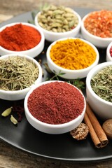 Different aromatic spices on wooden table, closeup