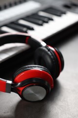 MIDI keyboard and headphones on grey table, closeup