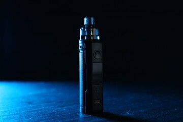 Modern electronic smoking device on black table