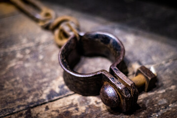 Genuine ancient iron handcuff on wooden floor from medieval times in England, prisoner wrist...