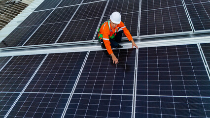 Solar power technician inspecting rooftop solar panels, performing maintenance and installation of...