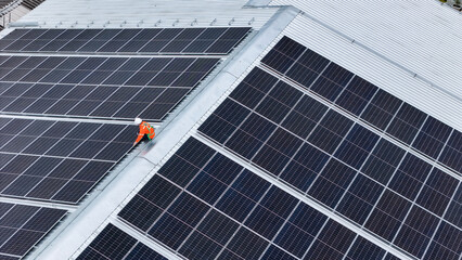 technician installs a large photovoltaic system on an industrial rooftop. ESG investment, and the...