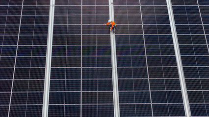 technician installs a large photovoltaic system on an industrial rooftop. ESG investment, and the...