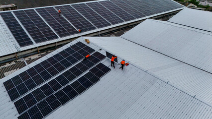 technician installs a large photovoltaic system on an industrial rooftop. ESG investment, and the...