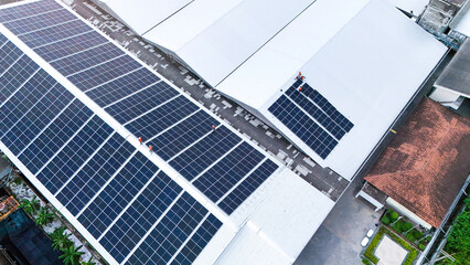 Aerial view of photovoltaic solar panels installed on the metal roof of a commercial building or...