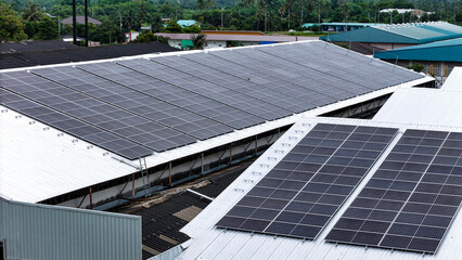 Aerial view of photovoltaic solar panels installed on the metal roof of a commercial building or...