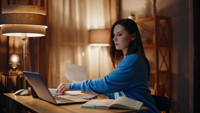 Stressed remote worker reading documents at dark home closeup. Worried woman