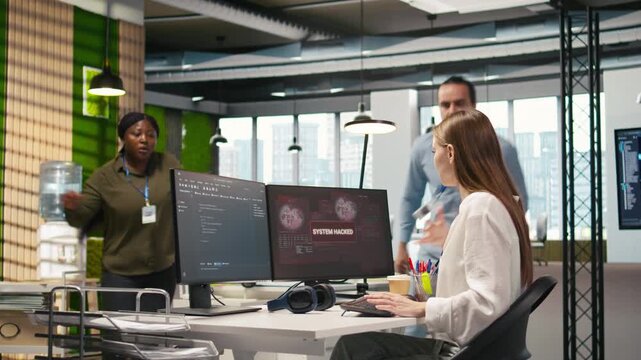Young inexperienced developer in office requests help from team to fix hacking attempt on corporate network. Intern assisted by colleagues to investigate unauthorized access alerts, camera A