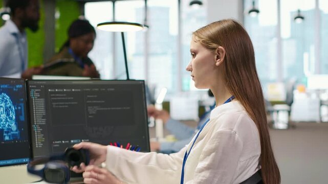 Junior dev developing software applications, optimizing code for performance, listening music. Young female engineer wearing headphones in office using AI to resolve bottlenecks, camera A