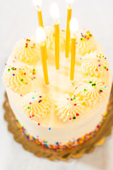 Birthday cake with frosting swirls and five candles