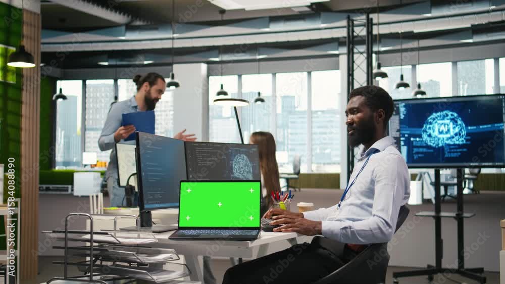 Poster technician next to office coworkers developing software applications using green screen laptop, inte