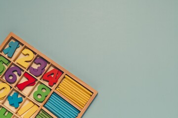Vibrant wooden tray with colorful educational numbers and counting sticks on light blue. Perfect for early childhood math, learning, and STEM.