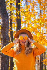 Woman faceless yellow sweater closing eyes with orange dahlia into camera Autumn Fall Bouquet for...