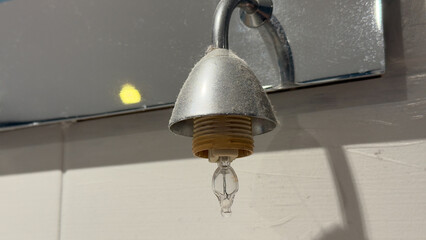 Dusty old bathroom vanity light with an exposed halogen bulb socket