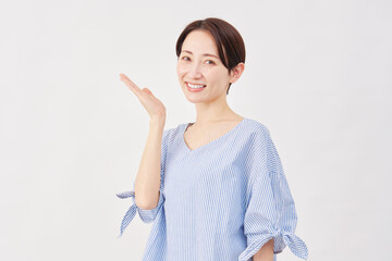 女性　ミドルエイジ　手のひらで左を指す　白背景