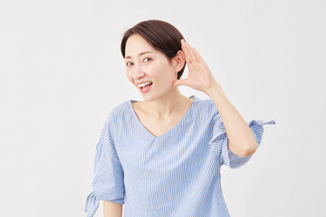 女性　ミドルエイジ　耳に手を当てて聞くジェスチャー　白背景　...
