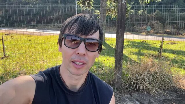 homem influenciador falando ao ar livre 