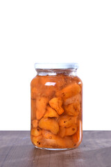 canned cashew and orange in a glass jar isolated, cashew halves in syrup, yellow fruit dessert, canned nectarine compote, sweet peeled cashew and orange slices in syrup on a white background
