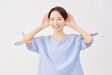 女性　ミドルエイジ　耳に手を当てて聞くジェスチャー　白背景　...