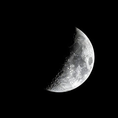 Naklejka premium Close up of a waxing crescent moon against a black background