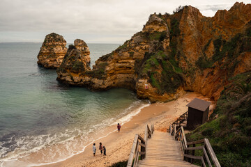 A beautiful high-angle view of Praia do Camilo in Lagos, showing tourists enjoying the sandy cove...