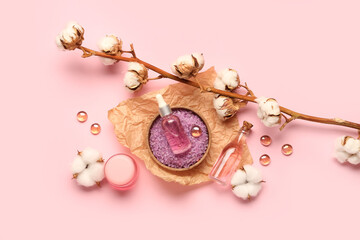 Composition with cosmetic products and cotton branch on pink background