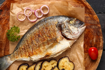 Plate with tasty grilled dorado fish on table
