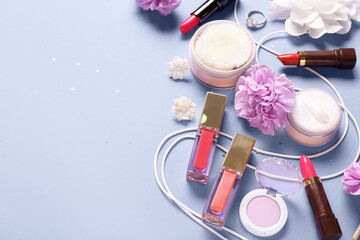 Makeup products with accessories, flowers and confetti on lilac background
