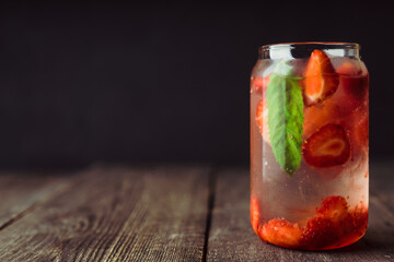 Refreshing summer cocktail with strawberries and rum on the rustic background. Selective focus.