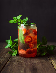 Refreshing summer cocktail with strawberries and rum on the rustic background. Selective focus.