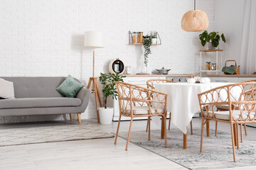 Interior of kitchen with white counters, grey sofa and dining table