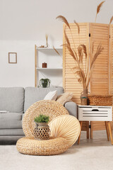 Interior of stylish light living room with grey sofa, coffee table and pampas grass