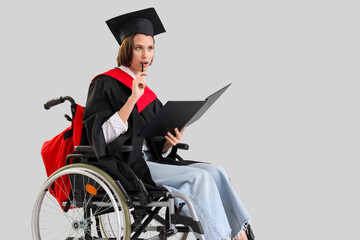 Thoughtful female graduate in wheelchair with folder on light background