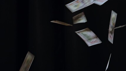 Dollar bills falling down from sky isolated black studio background closeup - Powered by Adobe