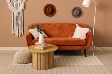 Interior of stylish living room with sofa, table and artificial eucalyptus in vase