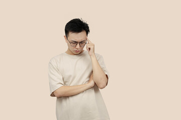 Thoughtful Young asian Man Contemplating Ideas While Standing Against a Neutral Background