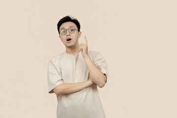Thoughtful Young asian Man Contemplating Ideas While Standing Against a Neutral Background