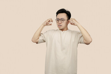 Frustrated young asian Man Expressing Anger With Aggressive Gesture in Casual Attire