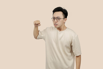 Frustrated young asian Man Expressing Anger With Aggressive Gesture in Casual Attire