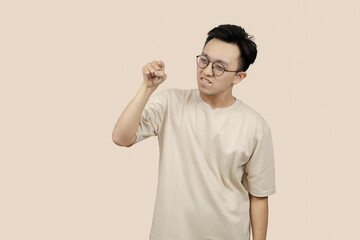 Frustrated young asian Man Expressing Anger With Aggressive Gesture in Casual Attire