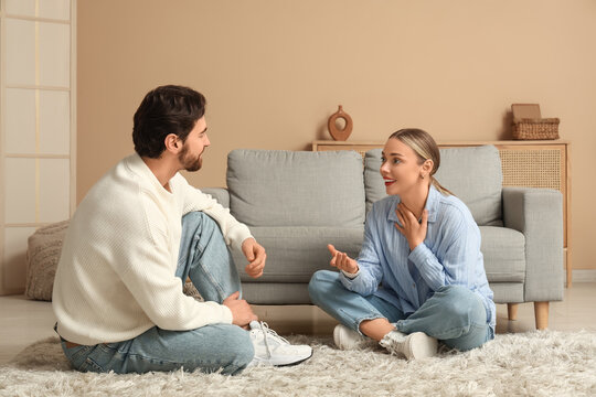 Young woman having dialogue with her husband at home