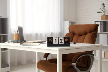 Flip calendar with date 12 OCTOBER on desk in office